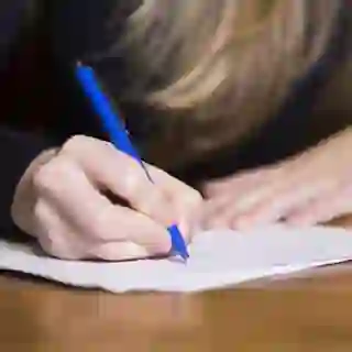 Female hand writing on paper