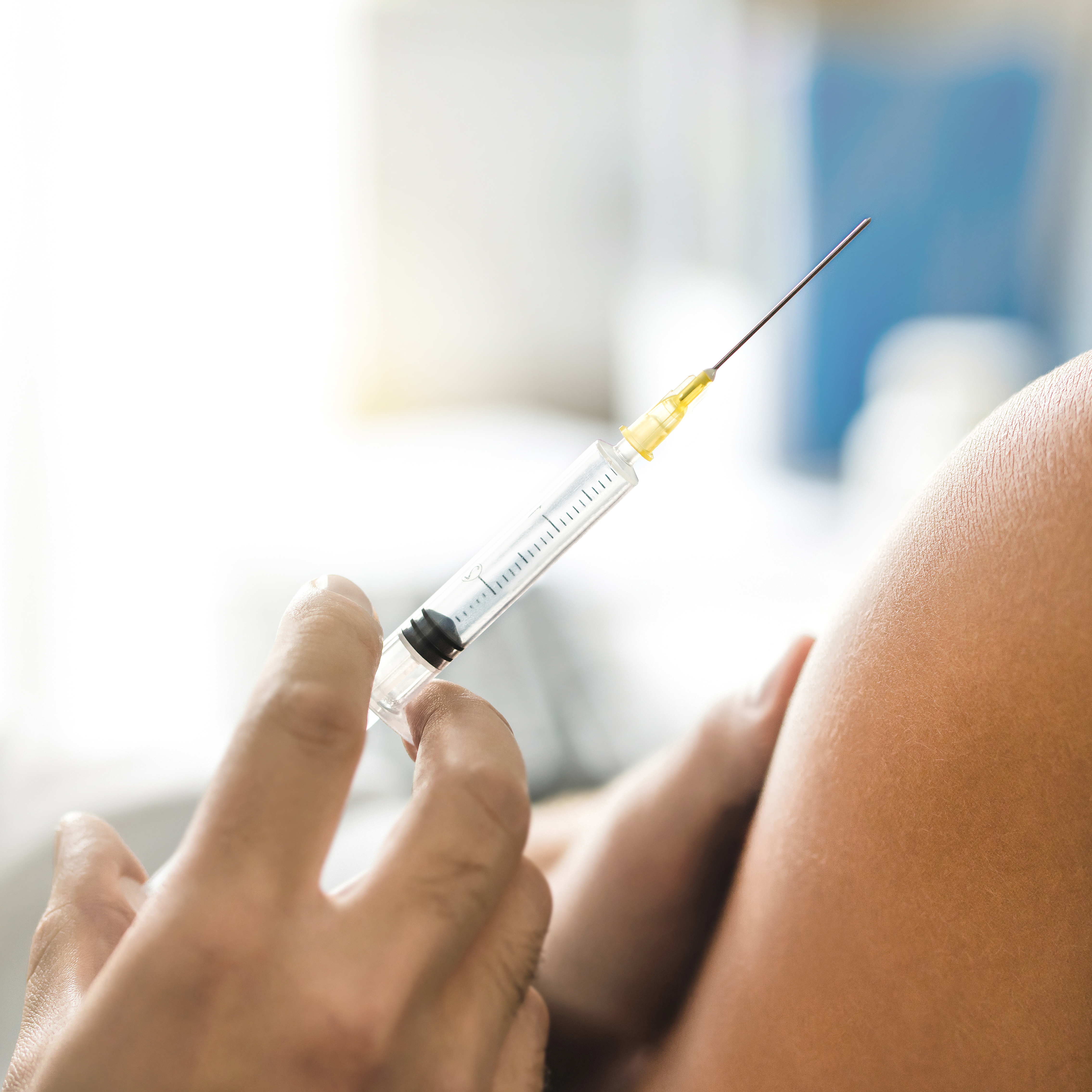 特写附近的一个医生拿着针注射病人的胳膊。