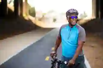 一个快乐的人骑着自行车站在小路上