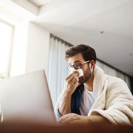 sick man typing on laptop