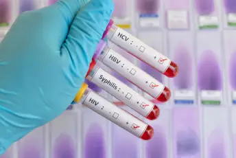 STD血液测试由护士举行橡胶手套。