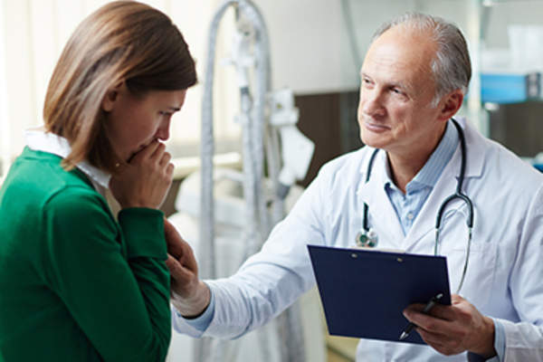 医生在安慰忧心忡忡的病人。