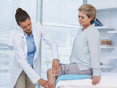 医生检查女性的膝盖。