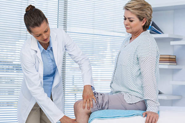 医生检查女性的膝盖。