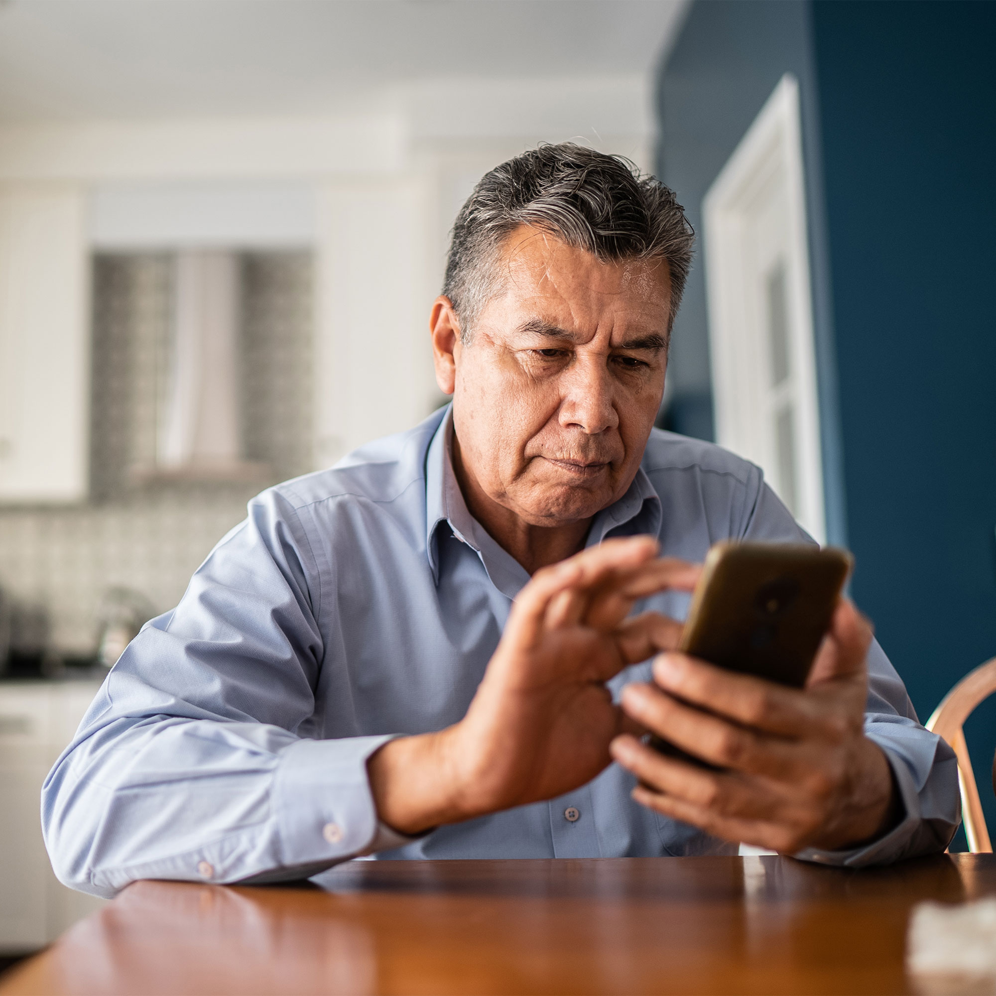 一名男子在家里使用智能手机
