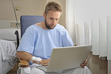 男性患者在笔记本电脑上寻找医院的在线健康信息。