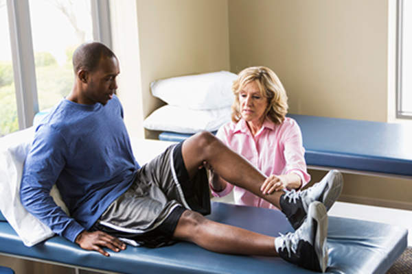 物理治疗师在看一个男人的腿。