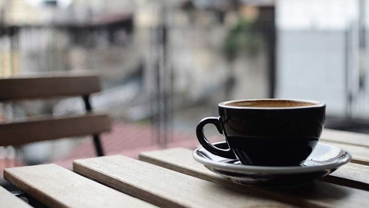 一杯放在户外木桌上的咖啡。