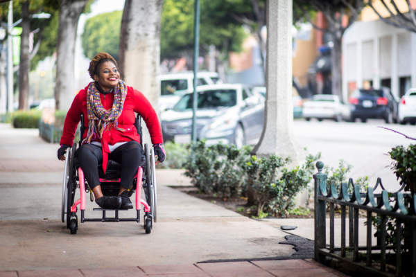 坐在轮椅上的女人微笑着走在街上