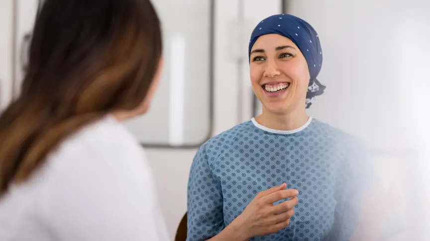 微笑的癌症患者与她的医生交谈。