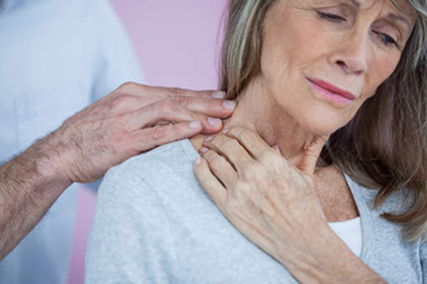 医生检查的女子与一个痛苦的脖子。