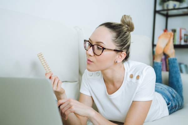 女人在沙发上看着避孕药