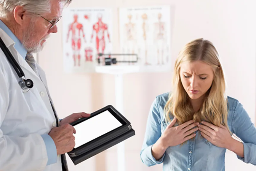 作为少妇采取笔记的医生描述酸反流症状。“loading=