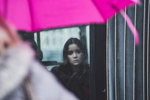 一个悲伤的女人望着窗外的雨