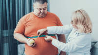医生测量肥胖男子的腰围。
