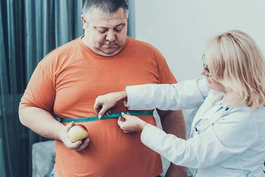 医生测量肥胖男人的腰部大小。