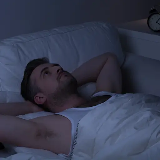 男人在床上醒来在一个黑暗的房间里