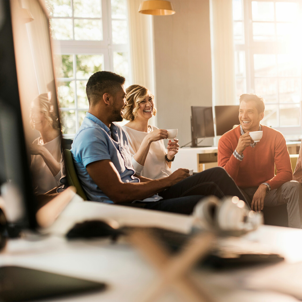 一群同事在办公室边喝咖啡边聊天