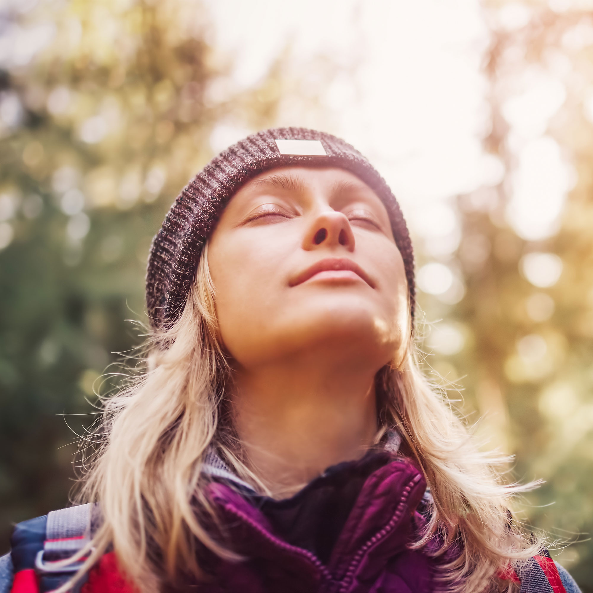 一位女士在徒步旅行时闭上眼睛沉思