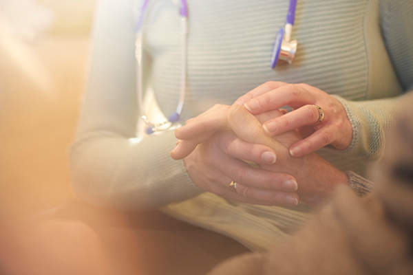 临终关怀护士牵着病人的手。