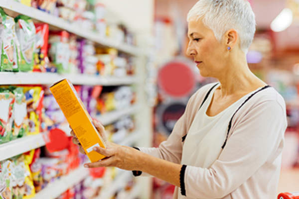 在杂货店里看食品标签的女人。
