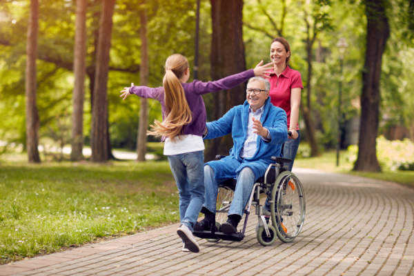欢快的残疾爷爷坐在轮椅上迎接他的孙女