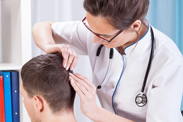检查医生对年轻人头皮。