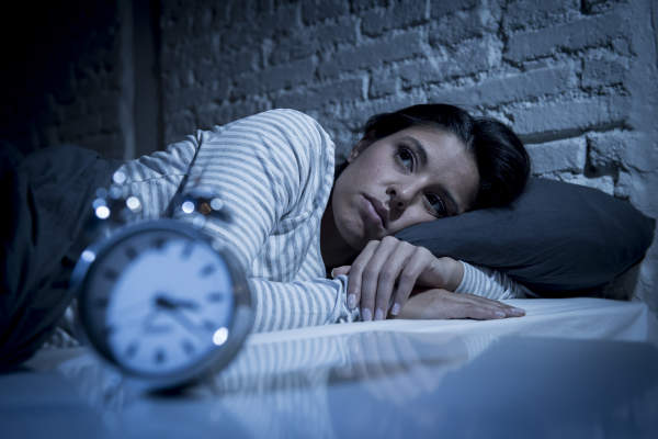 深夜躺在床上试图入睡的女人饱受失眠之苦