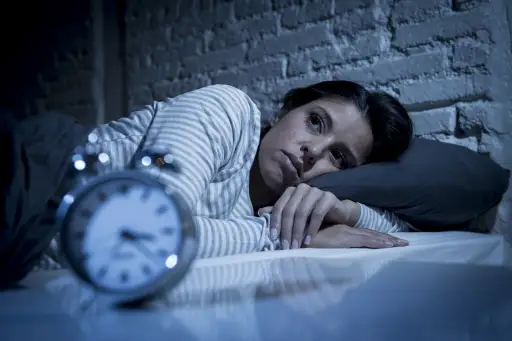 女人在床上睡得很晚，试图睡觉，遭受失眠