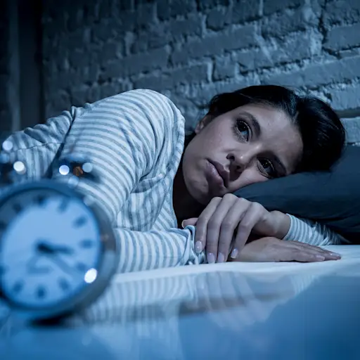 女人在床上睡得很晚,试图睡觉,遭受失眠