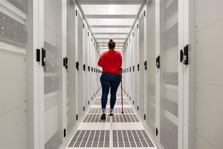 通过数据中心的年轻女子用拐杖行走