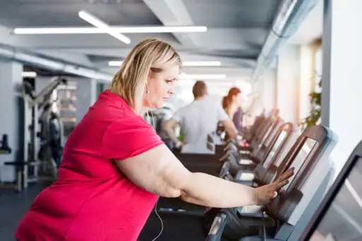 overweight woman walking on treadmill