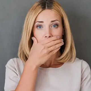 Woman covering her mouth.