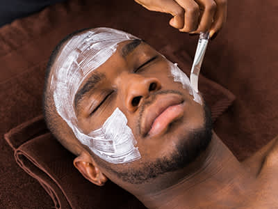 一个年轻人正在水疗中心做面部护理。