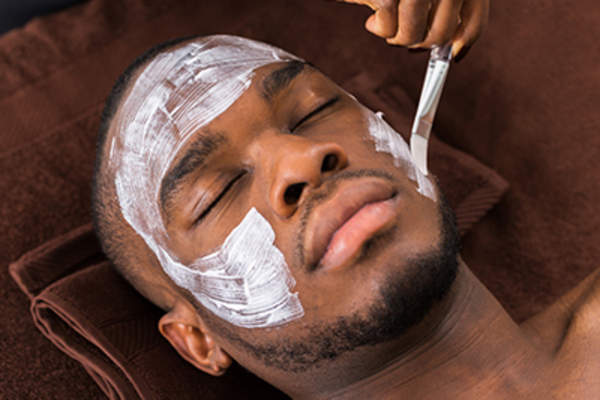 一个年轻人正在水疗中心做面部护理。