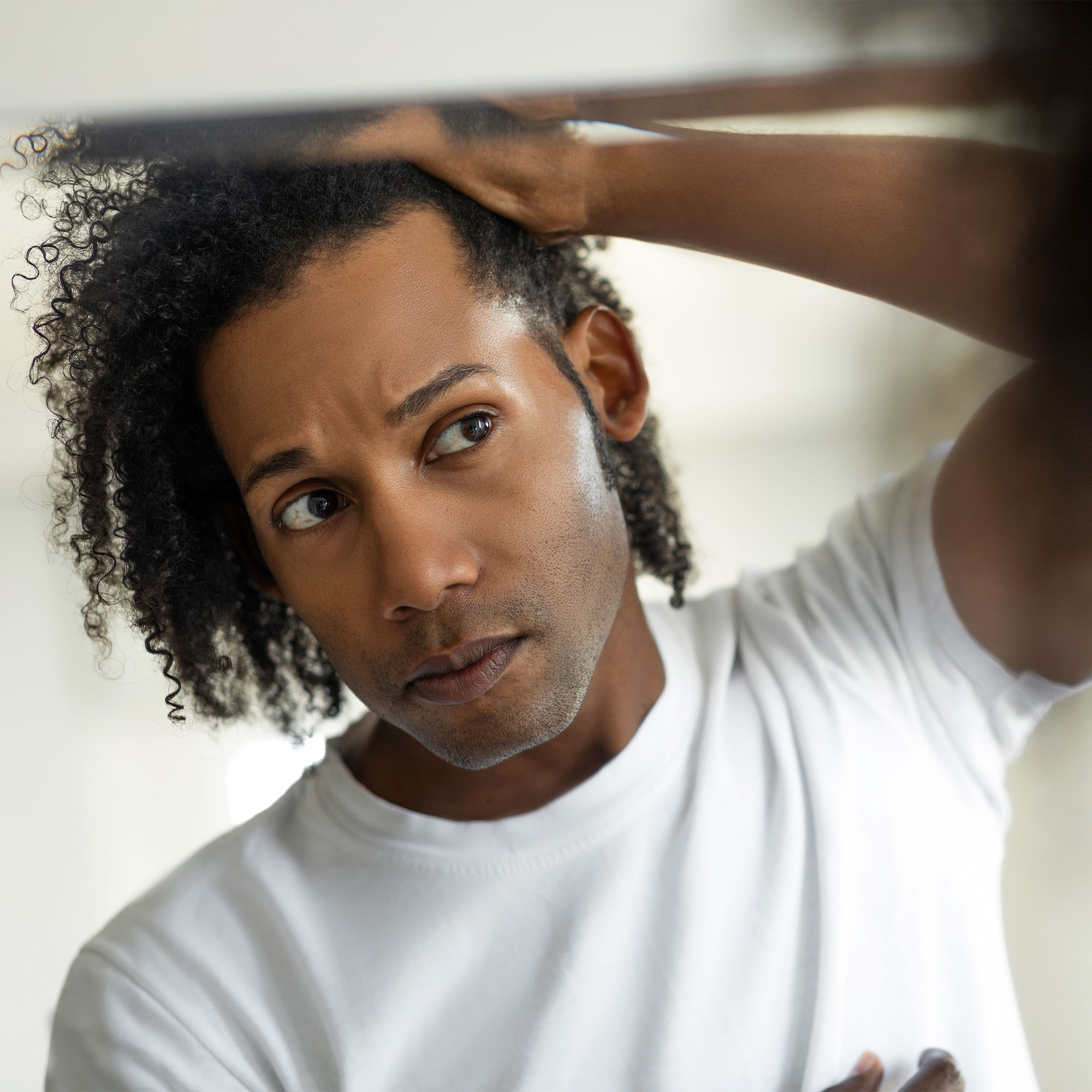 一个男人在镜子前检查他的头发