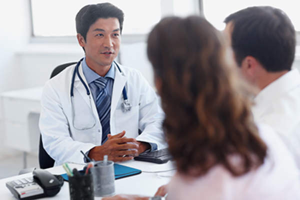Couple talking to a doctor together.