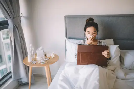 年轻的女人在床上看平板电脑