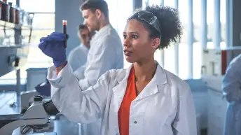 实验室技术人员正在分析一个血液瓶。