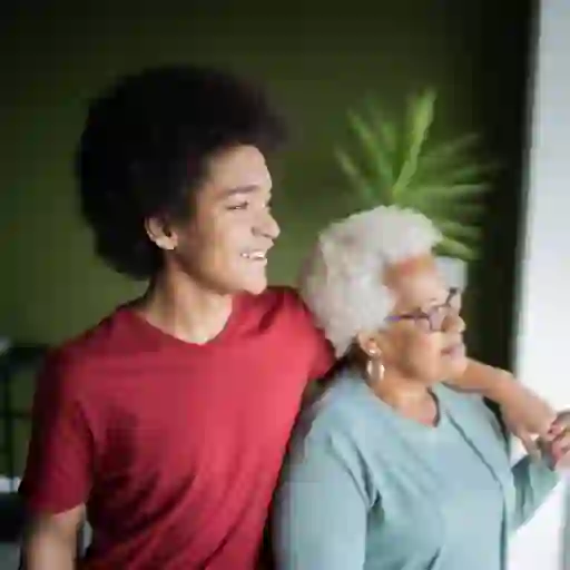 十几岁的男孩和他的祖母微笑在家里。