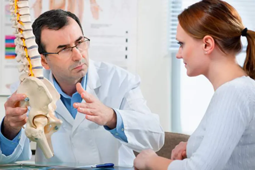 医生向妇女解释强直性脊柱炎。