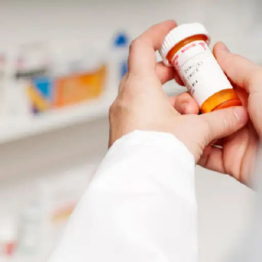 Pharmacist examining a bottle of prescription medicine