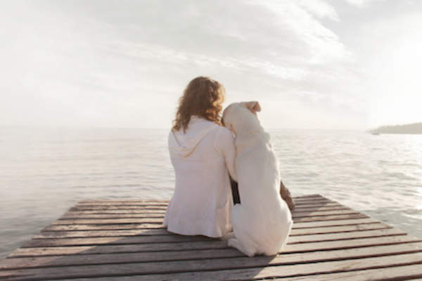 Woman with her dog at pier enjoying life.