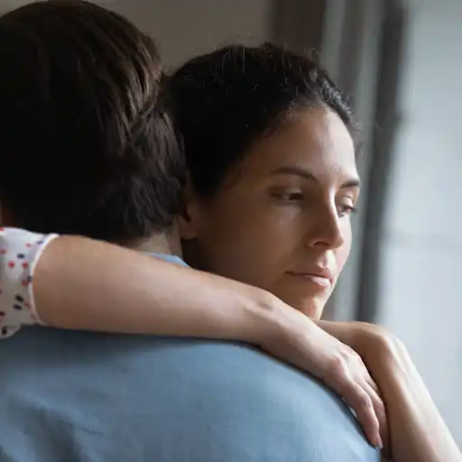 一个深思熟虑的女人拥抱她的男性伴侣的特写镜头。