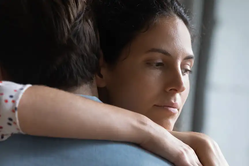 一个深思熟虑的女人拥抱她的男性伴侣的特写镜头。