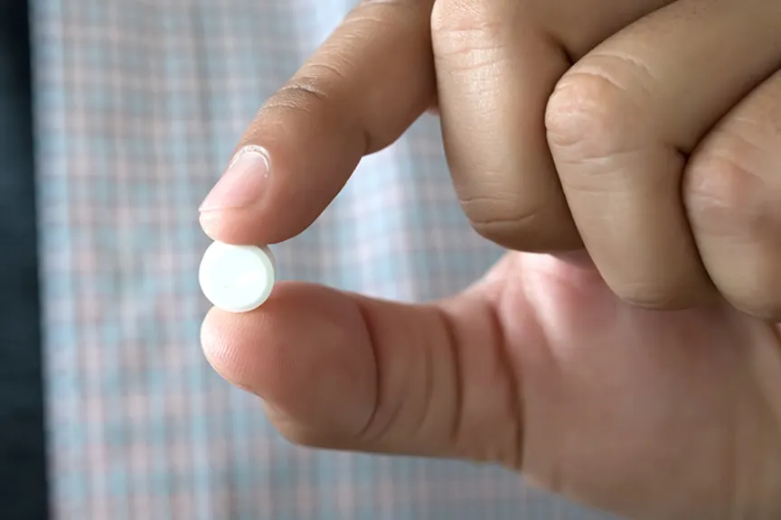 拿着阿司匹林的人在他的手指。