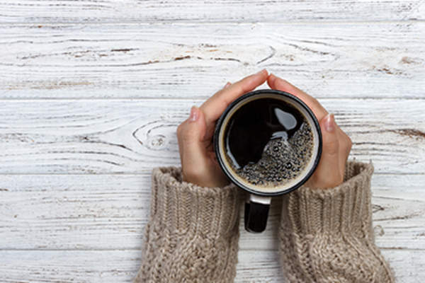 女人端着一杯咖啡。