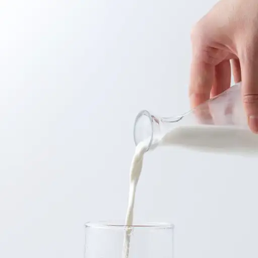 hand pouring milk