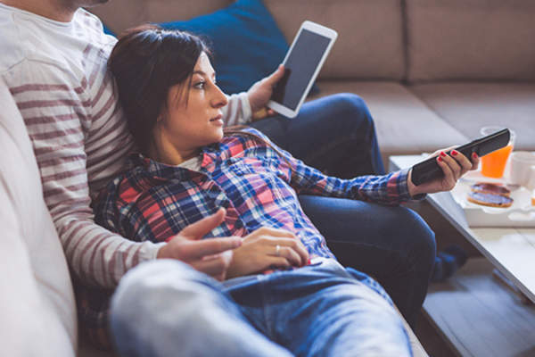 情侣在家里沙发上看电视。