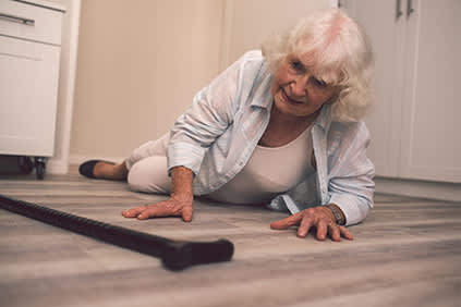 一位老妇人向前倒在地板上。
